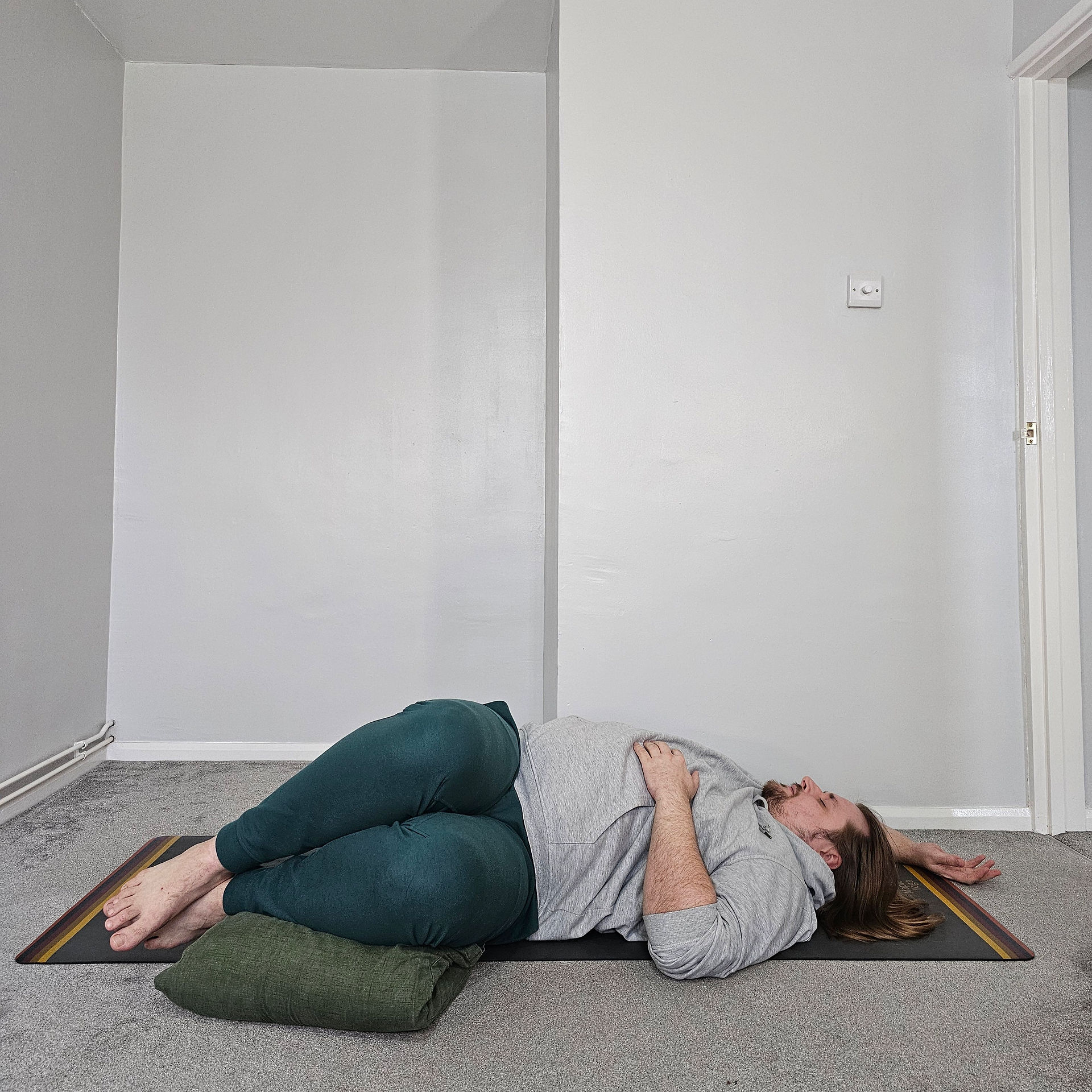 Sam is laying on the ground with his knees twisted over to the left.