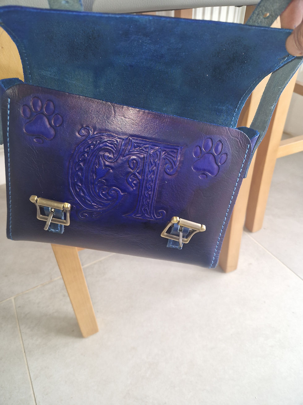 Close-up view of a leather handbag being stitched by hand