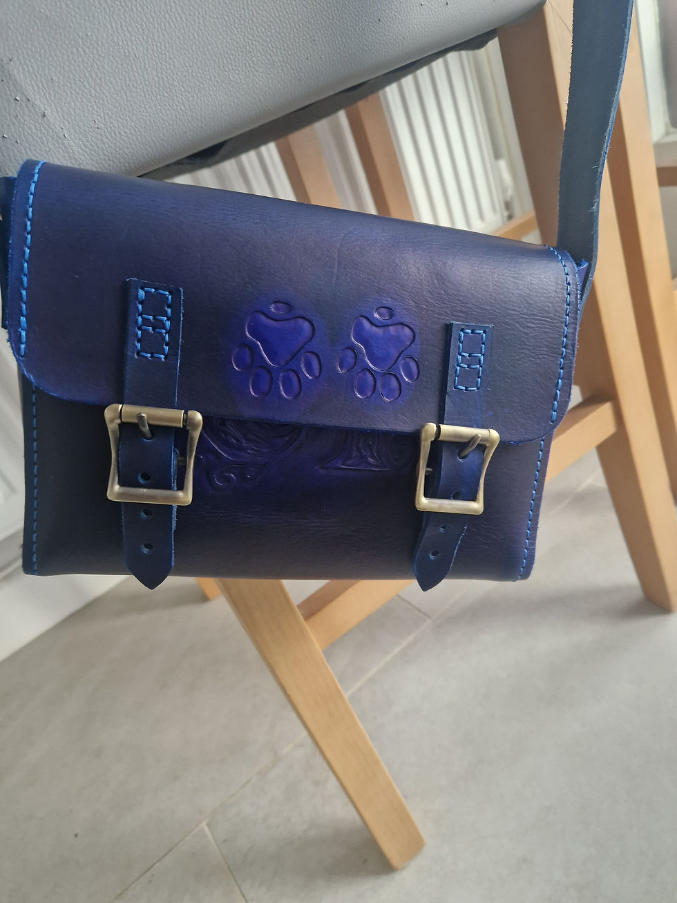 Eye-level view of a finished handcrafted leather handbag on a wooden table