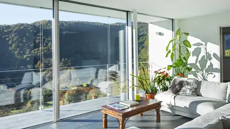 Residencia con eficiencia energética domótica — persianas motorizadas filtrando luz solar y reduciendo consumo