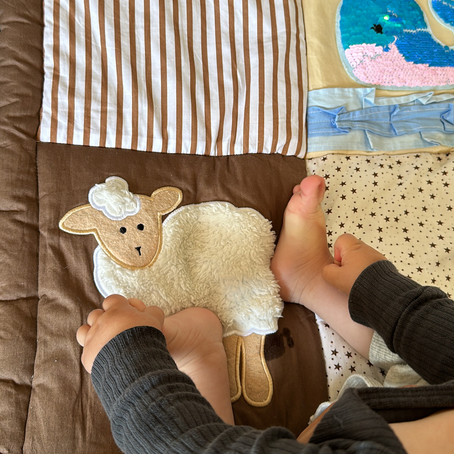 Baby feeling with their feet soft lamb on sensory play mat