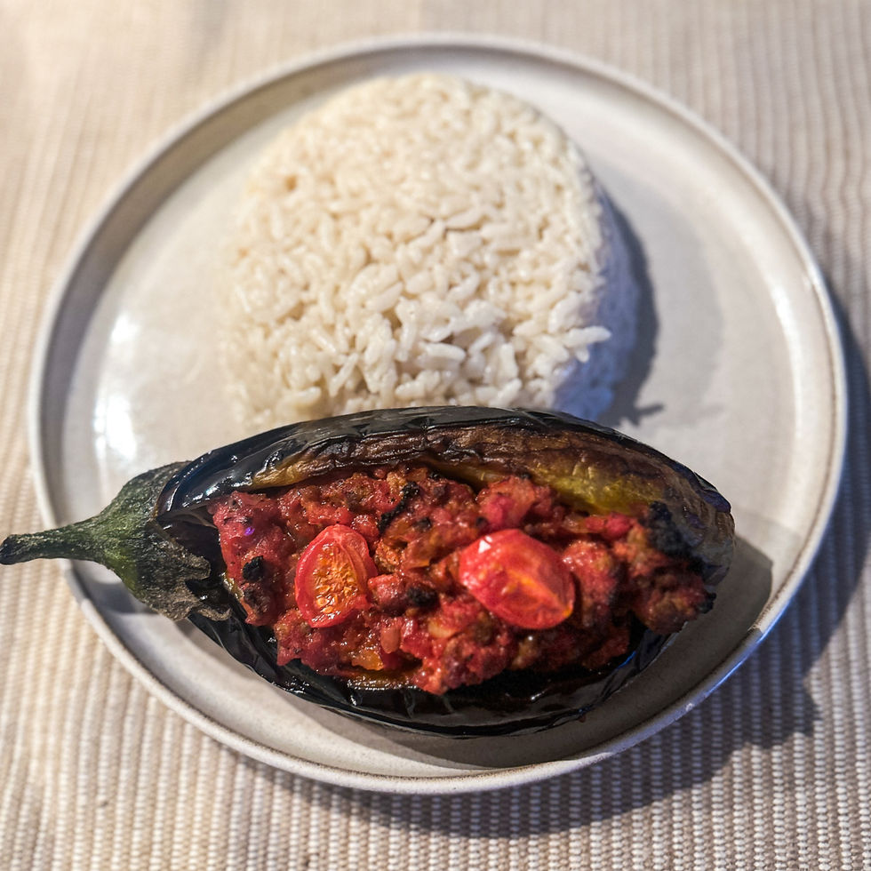 Kıymalı harçla doldurulmuş fırınlanmış karnıyarık, yanında sade pirinç pilavı ile birlikte servis edilmiş geleneksel Türk yemeği