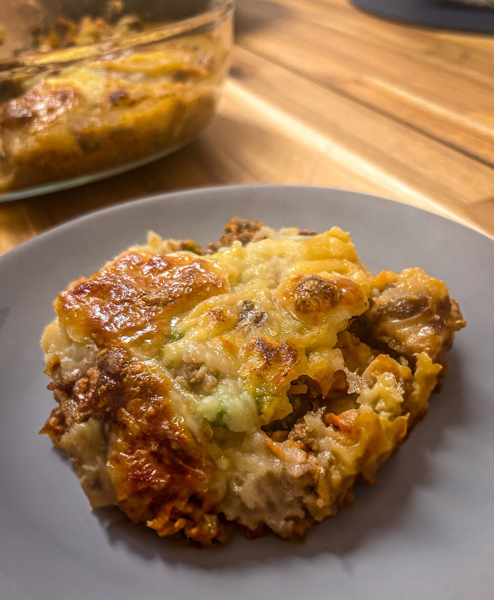 Eye-level view of a golden-brown cottage pie sitting on a rustic wooden table.