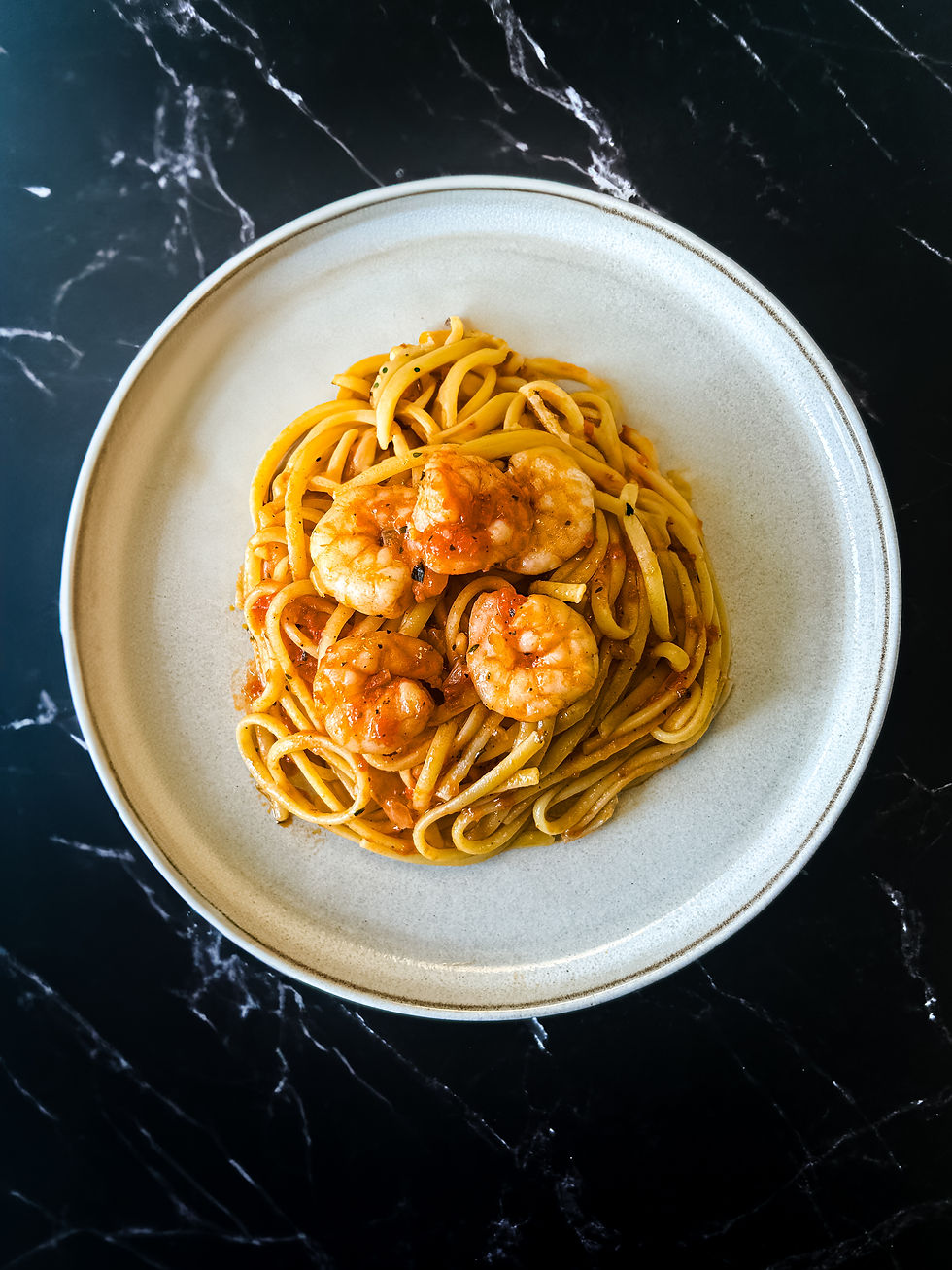 arımsaklı ve karidesli, domates soslu linguine makarna, sıcak olarak servis edilmiş deniz mahsullü ana yemek