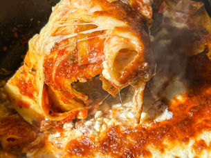 Tek tavada lor peynirli lazanya, üzerinde altın rengi erimiş mozzarella ile sıcak servis ediliyor.