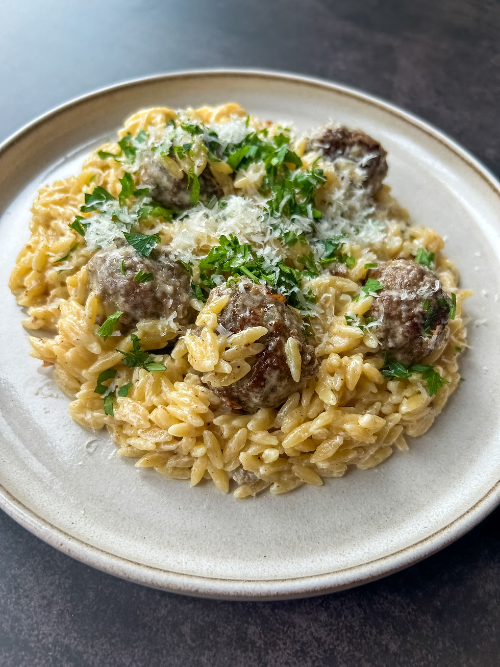 Creamy meatballs and orzo cooked in one-pan, served with chopped parsley and grated parmesan cheese
