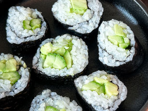 Çocuklar için hazırlanmış salatalık ve avokadolu sushi, sushi matı kullanılmadan yapılan, küçük parçalara dilimlenmiş ev yapımı sushi ruloları.