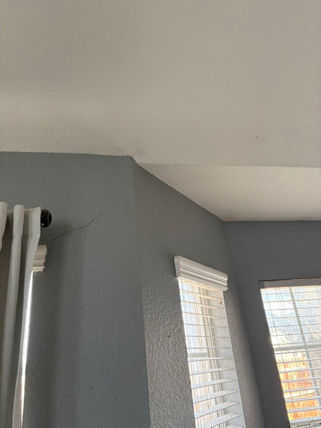 Wall and ceiling cracks before drywall repair in Aledo home