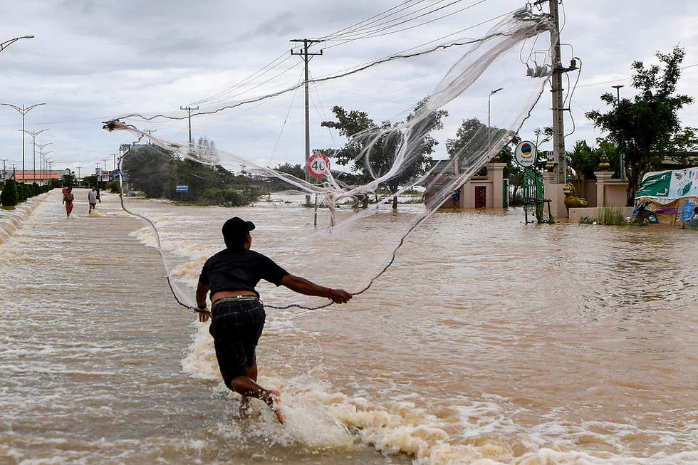 A man attempts to fish in floodwaters on the outskirts of Phnom Penh on October 18. Photo: Tang Chhin Sothy/AFP
