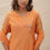 Thumbnail: model posing in saffron mirage by gul season 3 of color deep saffron where kurta is 100% chanderi creating a cool summer vibe 
