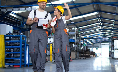 factory-workers-work-wear-yellow-helmets-walking-through-industrial-production-hall-discus