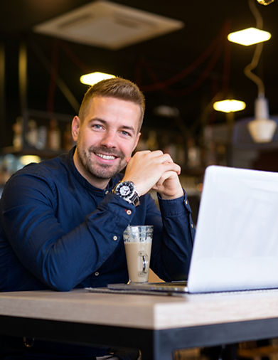 retrato-de-um-homem-sorridente-sentado-em-um-cafe-bar-com-seu-laptop_edited.jpg