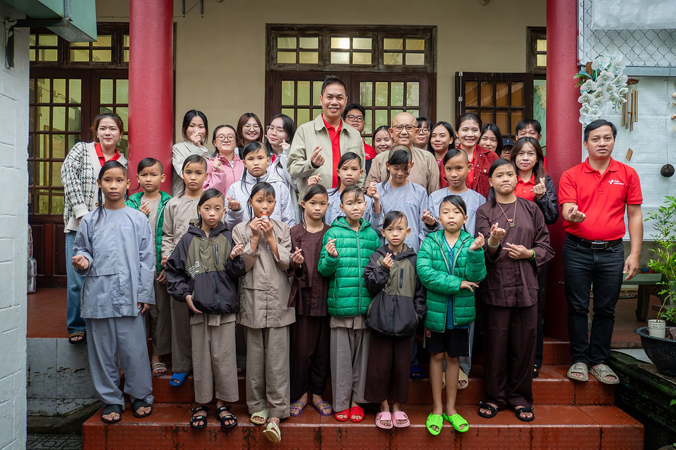 Group photo of Visit Indochina staff and children at Quang Chau Pagoda during a community support visit in Da Nang.