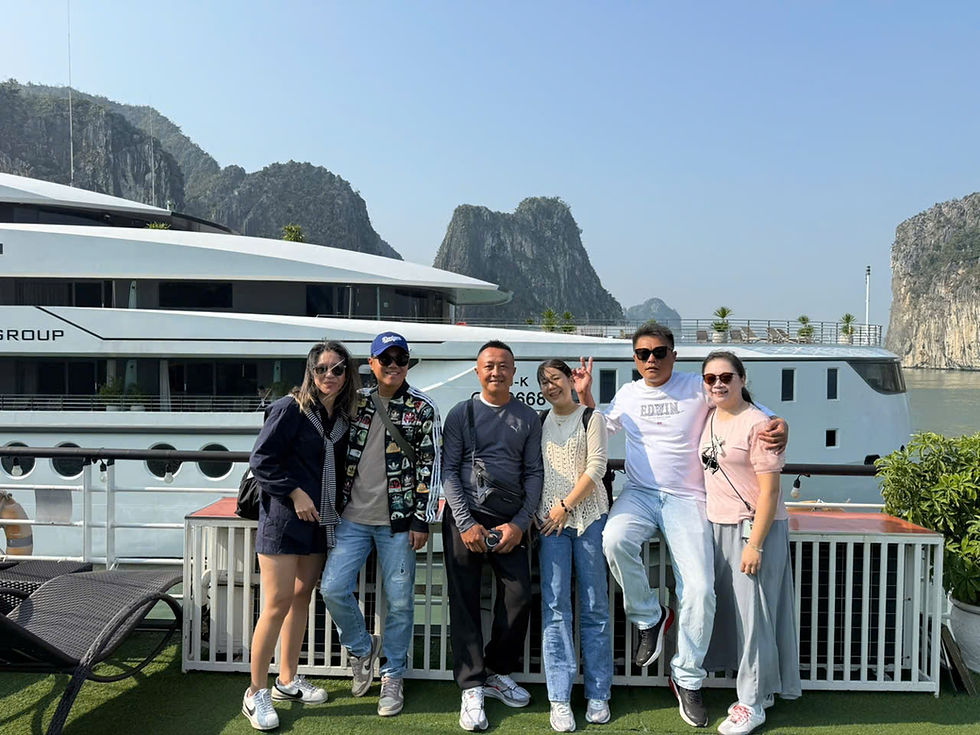 Taiwanese travelers enjoying a luxury cruise experience in Ha Long Bay with limestone karsts in the background
