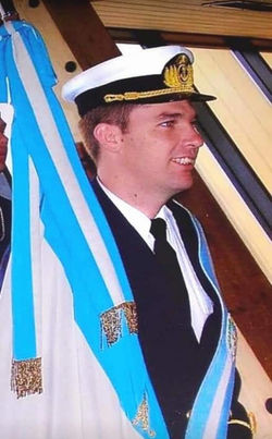 Tte. de Navío D. Wagner Clar portando el Pabellón Nacional