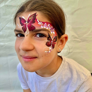 butterfly face painting with glitter and rainbow