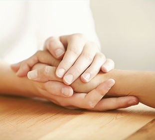 Two people holding hands supportively