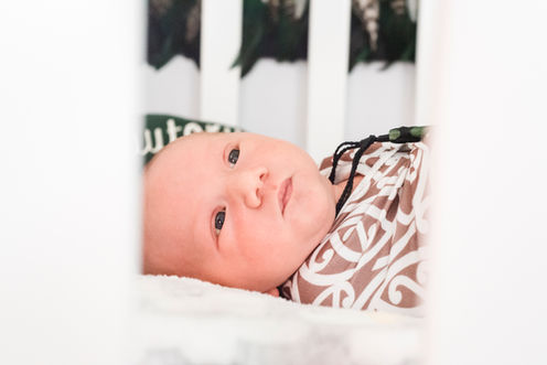 newborn-baby-laying-in-cot-with-eyes-wide-open-in-rockingham-perth-newborn-photographer