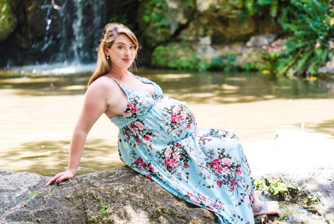 pregnant-mum-to-be-perched-on-rocks-at-waterfall-in-john-oldham-park-wearing-flowery-blue-dress-perth-maternity-photographer