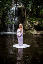 pregnant-mum-to-be-standing-in-the-waterfall-pond-at-john-oldham-park-wearing-purple-lace-dress-hired-from-the-client-closet-perth-holding-her-bump-with-long-blonde-hair-perth-maternity-photographer