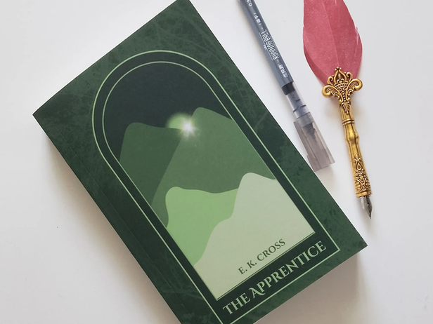 book of the apprentice on a white surface background with a pen and quill beside it.