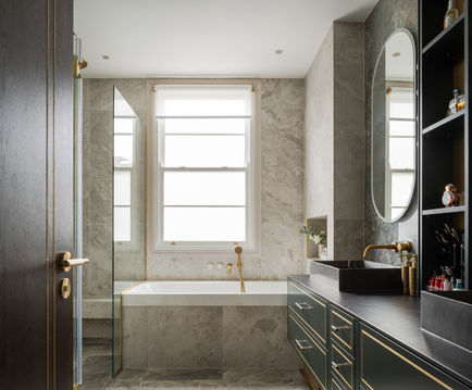 Master Bathroom, bespoke vanity unit, double bespoke unit, oval illuminated mirror, oval mirror, LED mirror, illuminated mirror, F&B studio green, green vanity unit, glossy feature tiles, wall tiles, beige tiles, brass inlay details, brass inset details, brushed gold taps, makeup lights, makeup mirror, shaving mirror, large vanity unit, porcelain counter, black porcelain countertop, grey marble countertop basins, green tiles, amozzonite tiles, taupe tiles, bath product niche, bathroom lights, glass enclosure, tiled shower bench, fumed oak bathroom door, display shelving, bathroom shelves