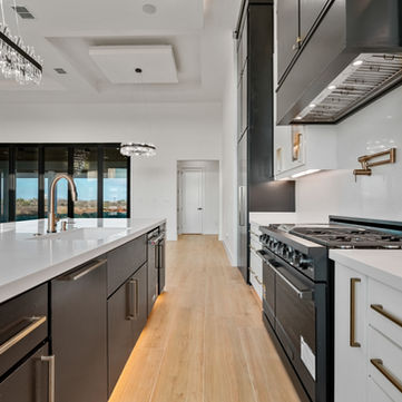 Custom kitchen with professional gas range oversized island quartz countertops and crystal pendant lighting at 3202 Orlov Trotter Drive Corpus Christi TX by Jade Homes custom home builder
