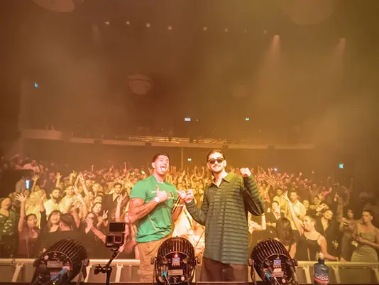 Two performers on stage in front of a packed crowd at a sold-out ParisLatino event at Jacy’z Big Stage in Gothenburg.