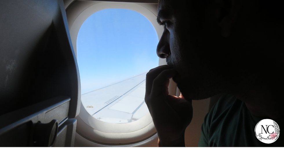 Man looking out of a plane window with anxiety. Fear of flying anxiety support and hypnotherapy for flight anxiety UK