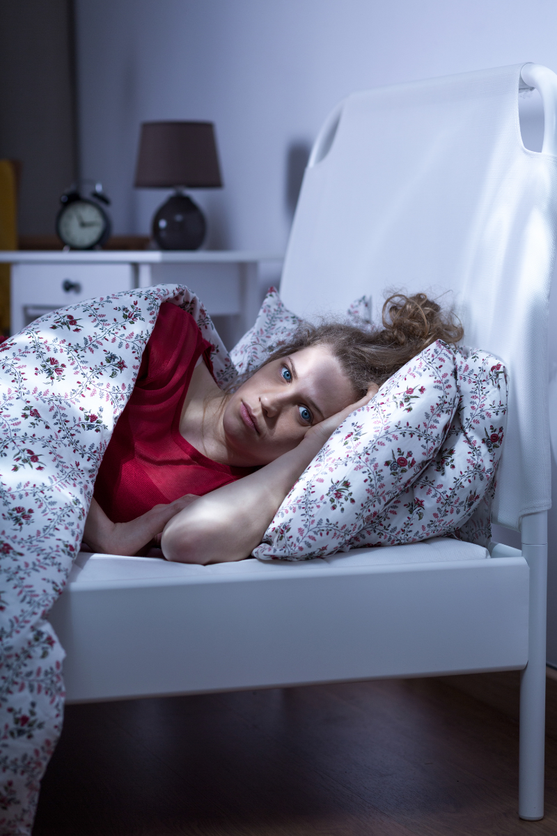 female struggling to sleep in bed as an anxiety symptom