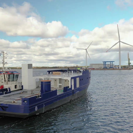 Tug towing multipurpose workboats' hull 