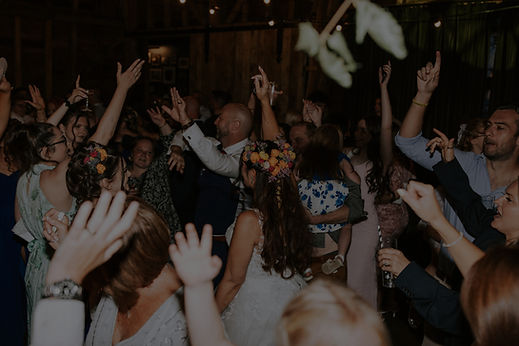 full wedding dancfloor party with everyones hands in the air