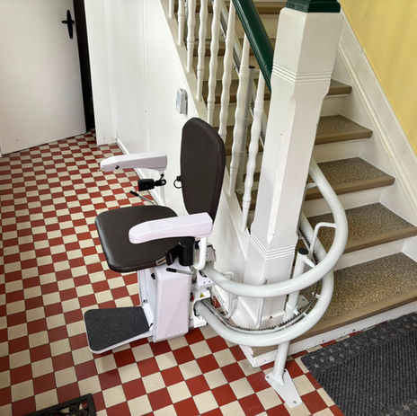 Nachher in Hamm: Treppenlift Alpha an einer kurvigen Holztreppe im Flur