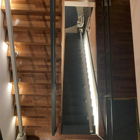 Treppenlift M1100: Blick von oben auf eine Holztreppe mit Treppenlift