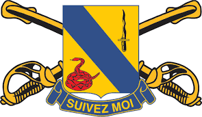 The unit insignia from the 14th Cavalry in front of crossed sabers, the U.S. military symbol of Cavalry, and the unit motto of “Suivez Moi” which is French for “follow me”. This is the unit crest that Captain Carbone wore when he commanded Troop C, 14th Armored Cavalry in Fulda, Germany.