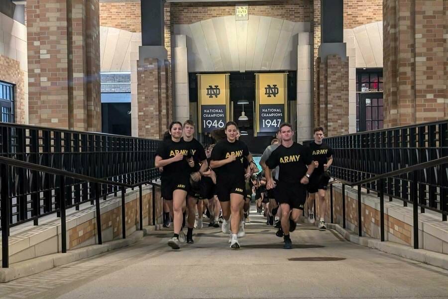 U.S. Army ROTC Cadets in athletic uniforms saying "ARMY" across their chests, running PT.