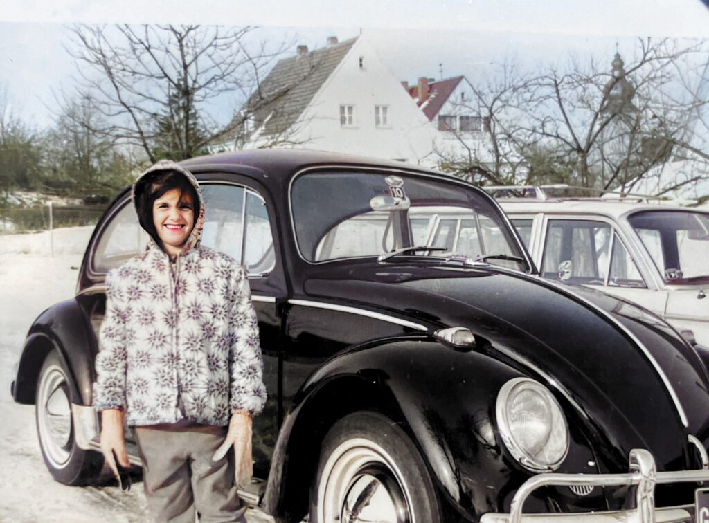 My oldest sister Lynne with our first German Volkswagen Beetle in Fulda, Germany.  All bundled up for the German winter.  Autobiography of Anthony J. Carbone.