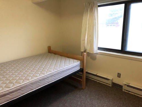 Empty cinder block single room of Fisher Hall at the University of Notre Dame