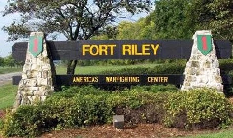 Fort Riley gate welcome sign saying "Fort Riley.  America's Warfighting Center" With the green patches with red numberal 1 for the 1st Infantry Division.  Biography of Dr. Anthony J. Carbone.