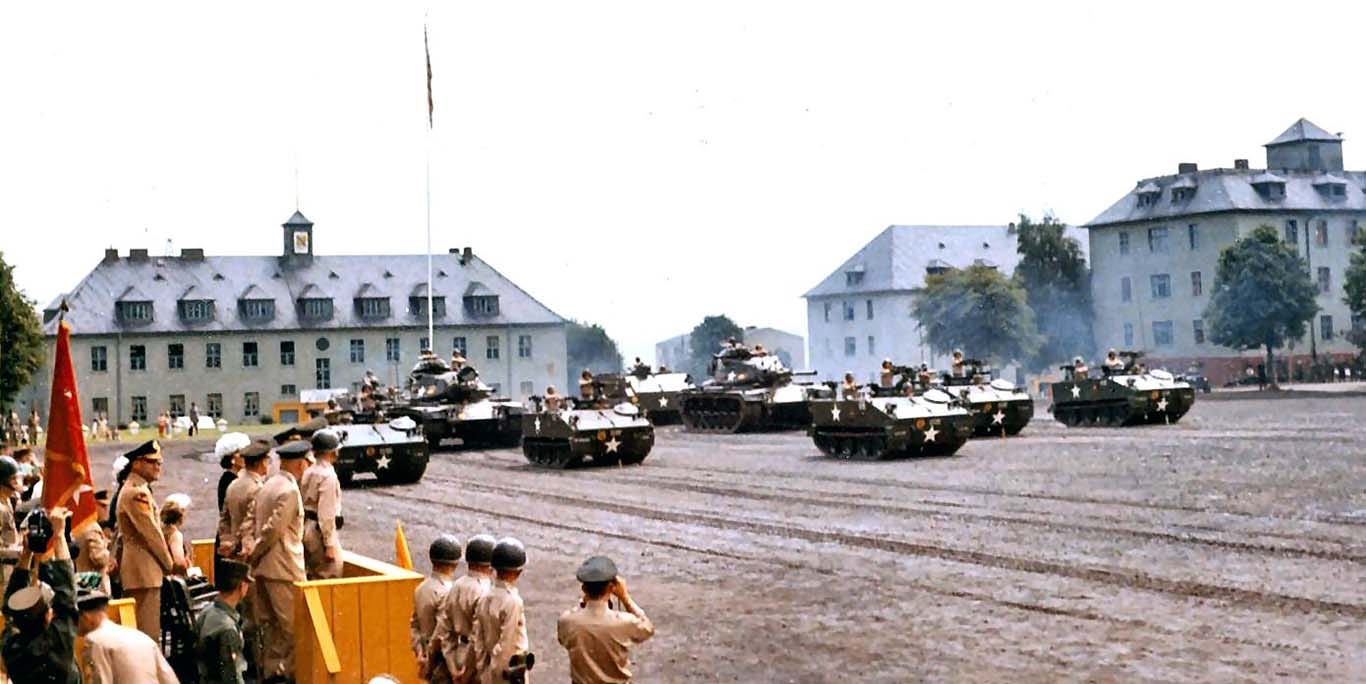 14th Armored Cavalry Regiment at Downs Barracks, Fulda, Germany (c. 1964). These were typical military buildings that the U.S. Army took over buildings from the Nazi forces after the war. This is a “Pass in Review” portion of an Army parade involving armored vehicles (M114 armored personel carriers used by the U.S. cavalry).