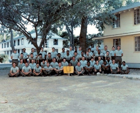 U.S. Army ROTC company at ROTC Advanced Camp with guidon and barracks in background.  Biography of Dr. Anthony J. Carbone.