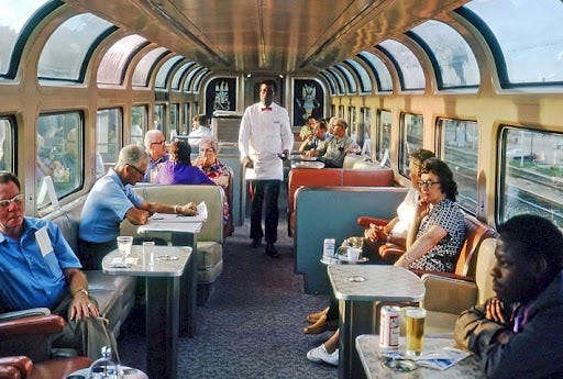 Photograph of a filled Amtrak Lounge Car with a waiter in white.  Autobiography of Dr. Anthony J. Carbone.