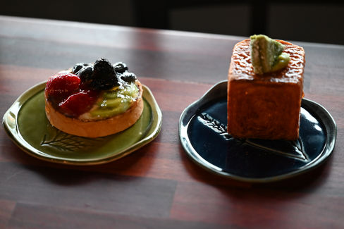 Handbuilt stoneware dessert plate and mug in moss green glaze styled with a chocolate dessert, handmade functional pottery from Plays In Mud pottery studio in West Asheville NC.