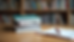 Eye-level view of a stack of PSAT prep books on a wooden desk