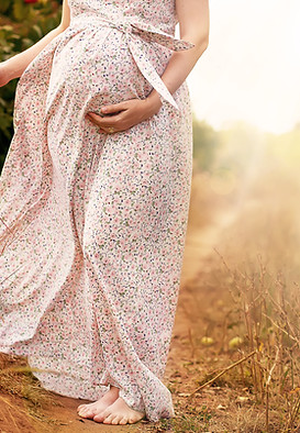 Femme enceinte en robe marchant dans la nature
