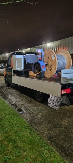 Vrachtwagen met kabeltrommel en materialen 's nachts