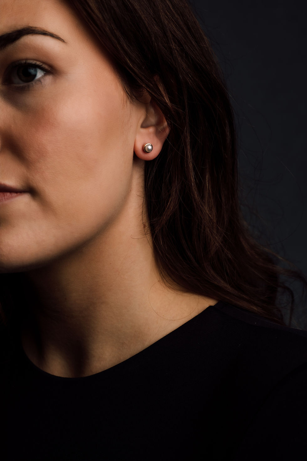 Women wearing a pair of pearl stud earrings