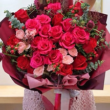 boquet of fuschia and re roses in floral wrapping paper