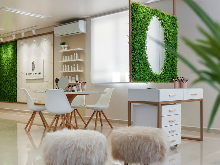 Consultório estético clean, em tons de branco e nude, dourado e jardim vertical.