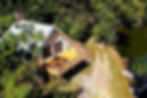 An aerial shot of a house perched on a hillside